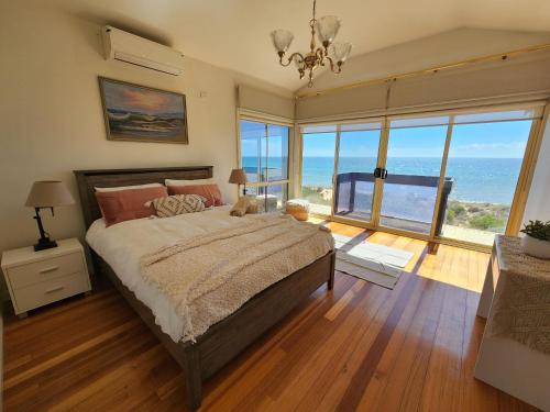 a bedroom with a bed with a view of the ocean at Sandy Shores Estate- Long Island in Frankston