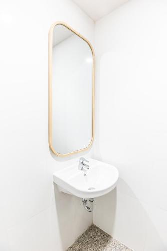 a bathroom with a sink and a mirror at KIYANA HOTEL SEMARANG in Jomblang