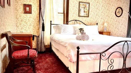 a bedroom with a bed with a stuffed animal on it at Hotel La More at The Bisbee Inn in Bisbee