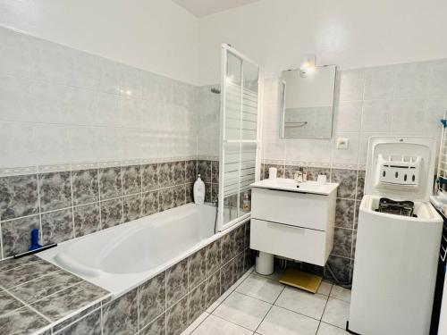 un bagno con vasca e lavandino di T2 à Cambo-Les-Bains, balcon, parking privé, près des thermes - FR-1-495-14 a Cambo-les-Bains
