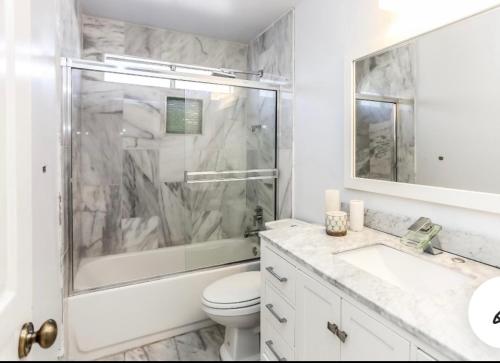 Un baño con ducha, inodoro y lavabo. en Shabby chic abode in Los Angeles ca, en Lomita