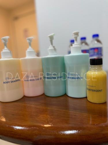 a group of four bottles of detergent on a wooden table at DAZA RESIDENCE @ TIMURBAY SEAFRONT KUANTAN in Kuantan