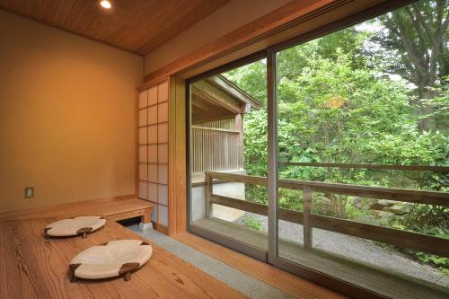 a room with a large window and a wooden floor at Syoubun in Minakami