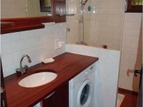 a bathroom with a sink and a washing machine at Maison Porto-Vecchio, 3 pièces, 6 personnes - FR-1-62-152 in Porto-Vecchio