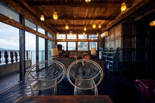 a room with three chairs and tables and windows at Guest House CARAPAN in Kagoshima