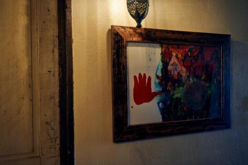 a painting of a hand on a wall with a light at Guest House CARAPAN in Kagoshima