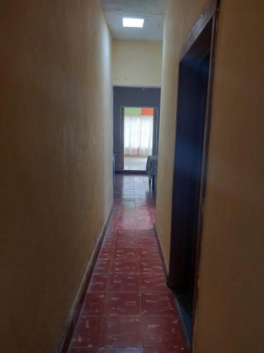 un couloir vide avec un sol en carrelage rouge et une chambre dans l'établissement La Casa del Descanso, à Tekax de Álvaro Obregón