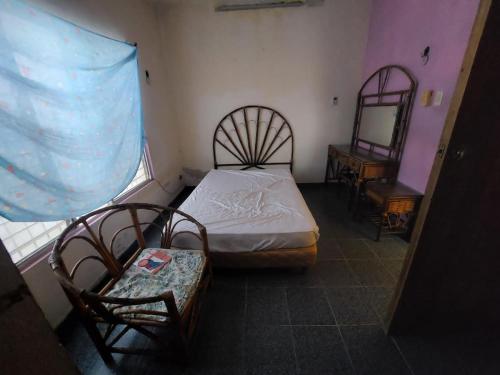 - une chambre avec un lit, deux chaises et une fenêtre dans l'établissement La Casa del Descanso, à Tekax de Álvaro Obregón