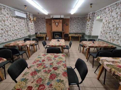 a dining room with tables and chairs and a fireplace at Kalamaja Hostel in Kuressaare