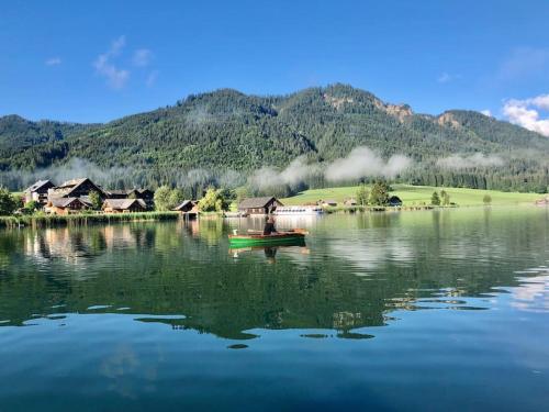 a person in a boat on a lake at Eco-Chalet Matschiedl in Tratten