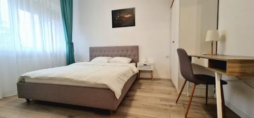 Schlafzimmer mit einem Bett, einem Schreibtisch und einem Schreibtisch in der Unterkunft Apartament momA Oradea in Oradea