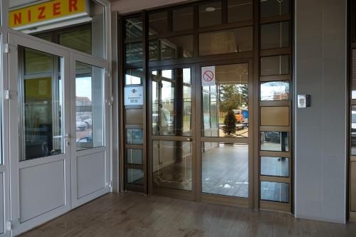 an entrance to an office building with glass doors at Smeštaj Tank, Pančevo in Salaši