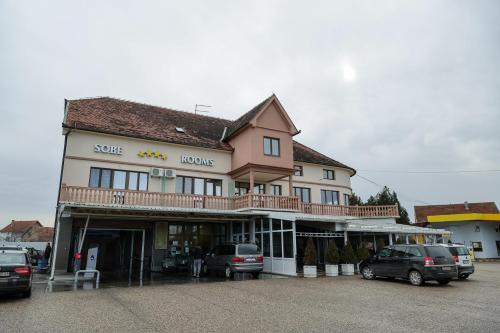 a large building with cars parked in a parking lot at Smeštaj Tank, Pančevo in Salaši