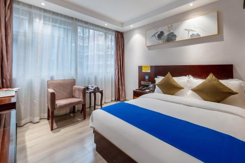 a hotel room with a bed and a chair and a window at Slowcom┃Yuebei Hotel （Guangzhou Provincial Government) in Guangzhou