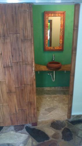 a bathroom with a sink and a mirror at La Choza Guesthouse in Santo Domingo