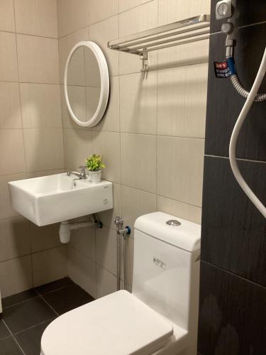 a bathroom with a toilet and a sink and a mirror at Golden Oceanview at Icon Residence in Kuala Terengganu