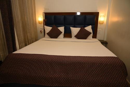 a bedroom with a large bed with a black headboard at Hotel Guru Surbhi in Pāonta Sāhib