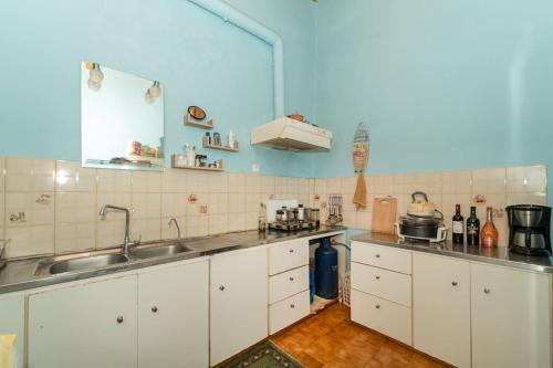 a kitchen with white cabinets and a sink at Dimizis in Methoni