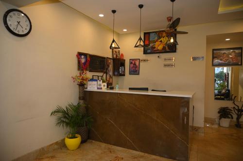 a lobby with a counter and a clock on the wall at Hotel Guru Surbhi in Pāonta Sāhib