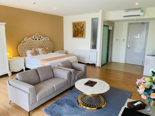 a bedroom with a bed and a couch and a table at Wafa Hotel & Apartment in Kampong Mata Mata