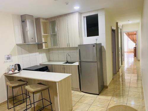 a kitchen with a counter and a refrigerator at Wafa Hotel & Apartment in Kampong Mata Mata