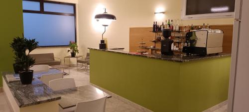 ヴェンティミリアにあるHotel Postaの緑豊かなバー(白い椅子付)のあるレストラン