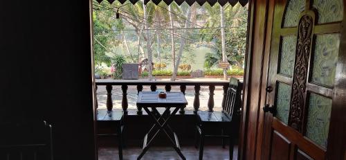 Habitación con vistas a un balcón con mesa y sillas. en Phousi Guesthouse 2 en Luang Prabang