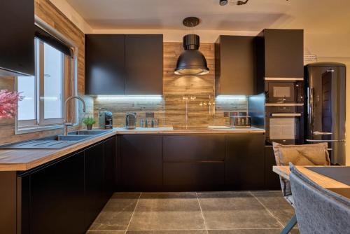 uma cozinha com armários pretos e um lavatório em Eden Boutique Smart Home em St. Paul's Bay