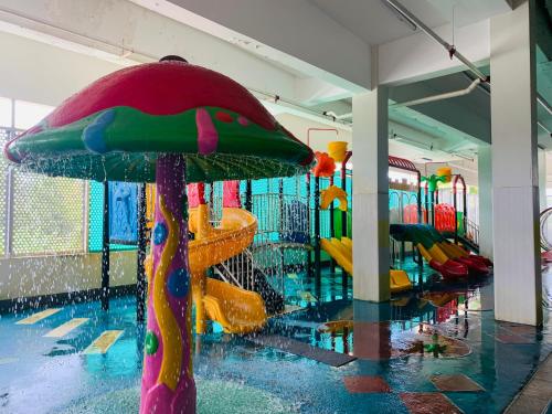a pool with a colorful umbrella in a water park at Wafa Hotel & Apartment in Kampong Mata Mata