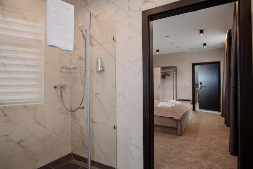 ein Bad mit ebenerdiger Dusche und ein Schlafzimmer in der Unterkunft Hotel Boutique Refael in Truskawez