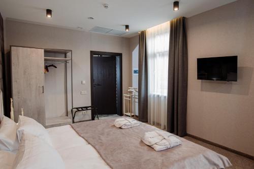 a bedroom with a large bed with towels on it at Hotel Boutique Refael in Truskavets