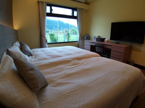 新城鄉的住宿－太魯閣惠宇民宿，卧室设有一张白色大床和一扇窗户。