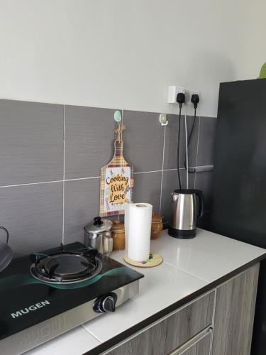 a kitchen counter top with a stove top oven at Ana Homestay D'Airport in Melaka