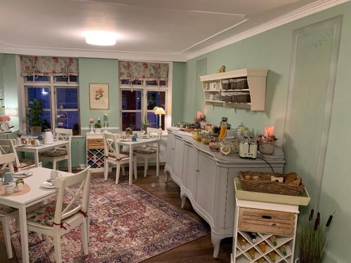eine Küche mit einer Theke, Tischen und Stühlen in der Unterkunft Hotel Bed & Breakfast am Dom in Schleswig