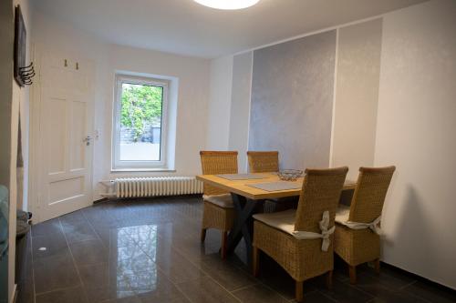 d'une salle à manger avec une table, des chaises et une fenêtre. dans l'établissement Ferienwohnung mitten in Saarburg, à Sarrebourg