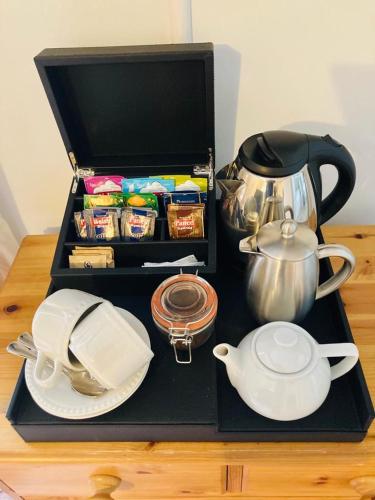 a black tray with a tea set and a tea kettle at Ty Mawr Country Hotel & Restaurant in Carmarthen