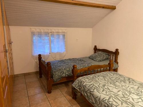 une chambre avec deux lits et une fenêtre dans l'établissement Au bonheur des animaux, à Auriébat