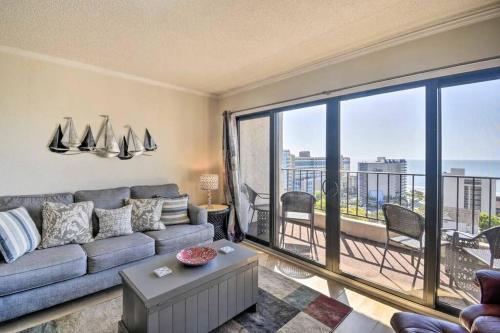 a living room with a couch and a large window at Coastal Escape Penthouse with Ocean Views in Myrtle Beach