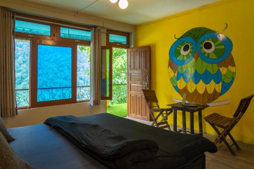 a bedroom with a large owl mural on the wall at Whoopers Hostel Tosh in Tosh