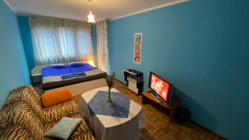 niebieski pokój z łóżkiem i telewizorem w obiekcie Аria B&B w Burgas