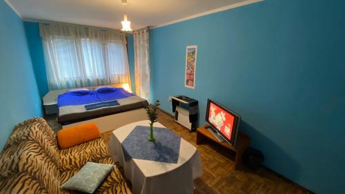 Una habitación azul con una cama y un televisor. en Аria B&B, en Burgas