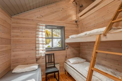 a log cabin with two bunk beds and a window at Gaupnetunet Hotell og Hytter in Gaupne