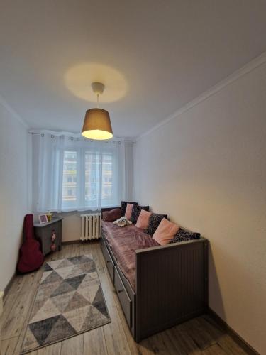 a living room with a couch and a large window at Apartament Górska Panorama in Szklarska Poręba