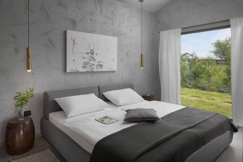 een slaapkamer met een groot bed en een raam bij Terra Histria - Boutique Stone House in Oprtalj