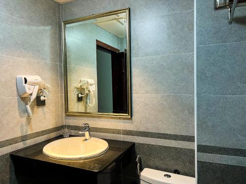 a bathroom with a sink and a mirror and a toilet at Ven Hồ Hotel in Hanoi