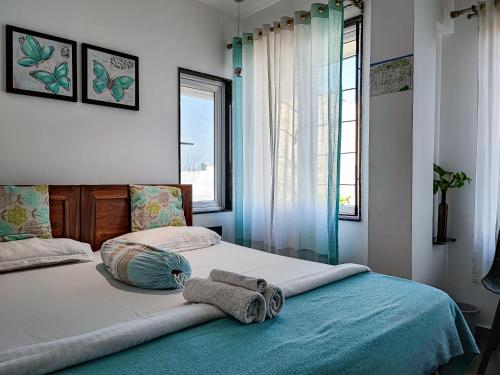 1 dormitorio con 1 cama con 2 toallas en Mel Ville, en Pondicherry