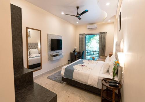 a bedroom with a large bed and a tv at The Verda De Miranda Resort Morjim North Goa in Morjim