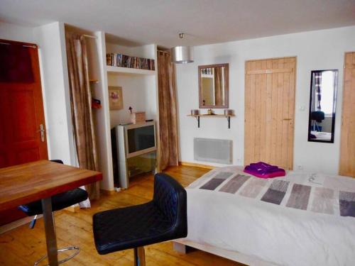 une chambre avec un lit, une table et un bureau dans l'établissement Studio cosy au cœur de la nature, à Gorze