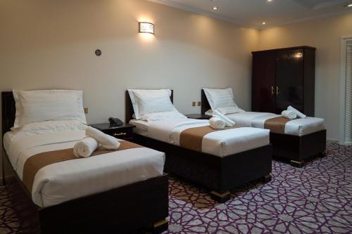 a hotel room with two beds with white pillows at Almudawah Hotel in Ţurayf