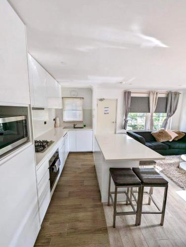 a kitchen with white cabinets and a counter top at Lotus Stay Manly - Apartment 31E in Sydney